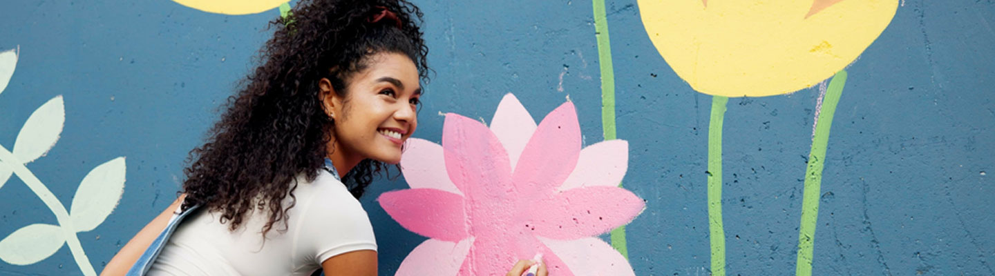 Jeune femme peignant une murale