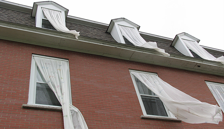 projets-art-infiltrer-habiter.jpg Façade de bâtiment en briques rouges avec plusieurs fenêtres et lucarnes.