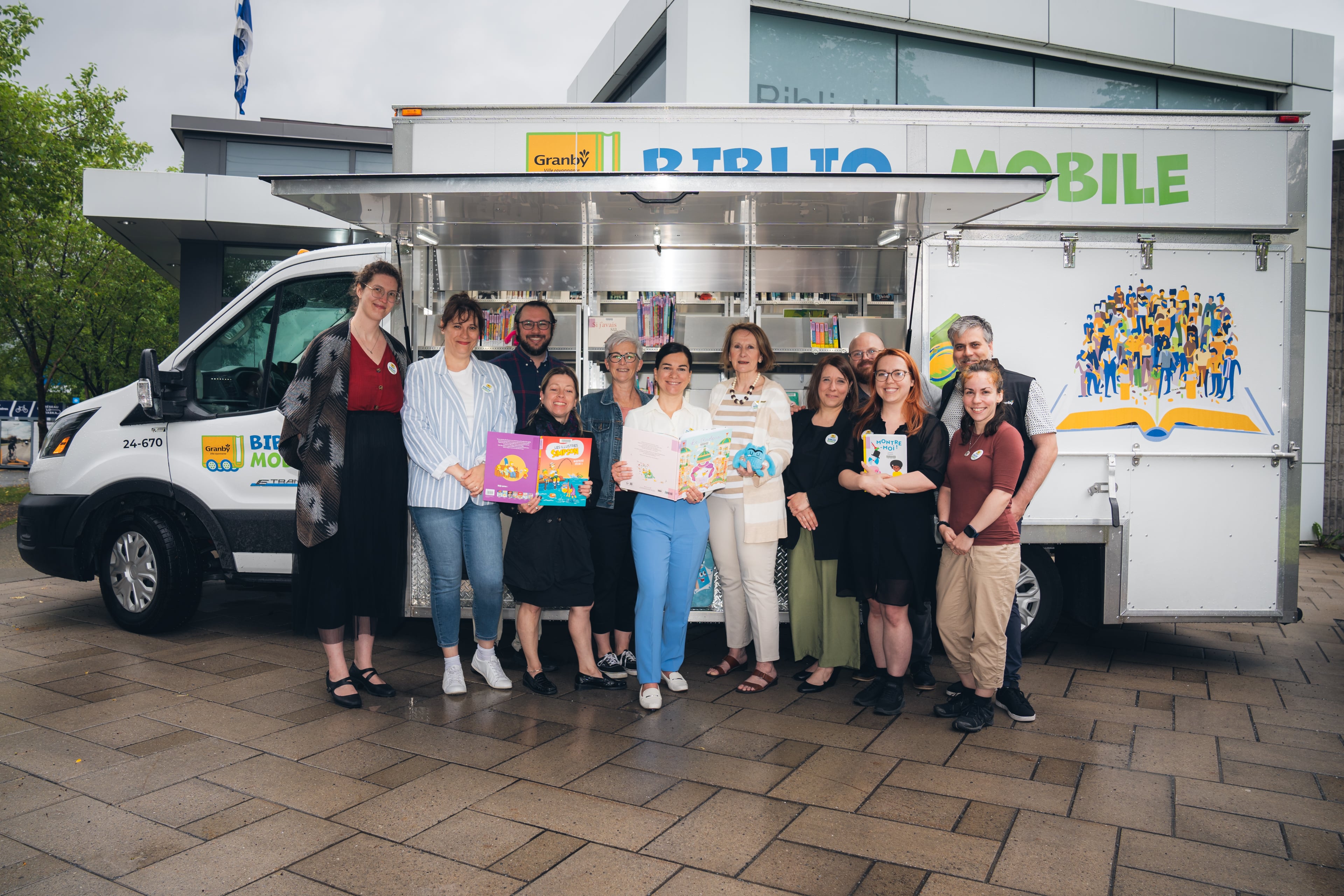 Deux personnes avec un livre, lors du lancement d’une bibliothèque mobile 100 % électrique à Granby.