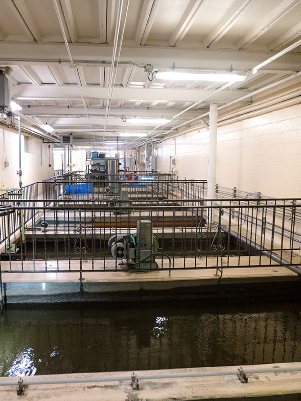 Grand bassin intérieur éclairé, entouré de passerelles et d’équipements.